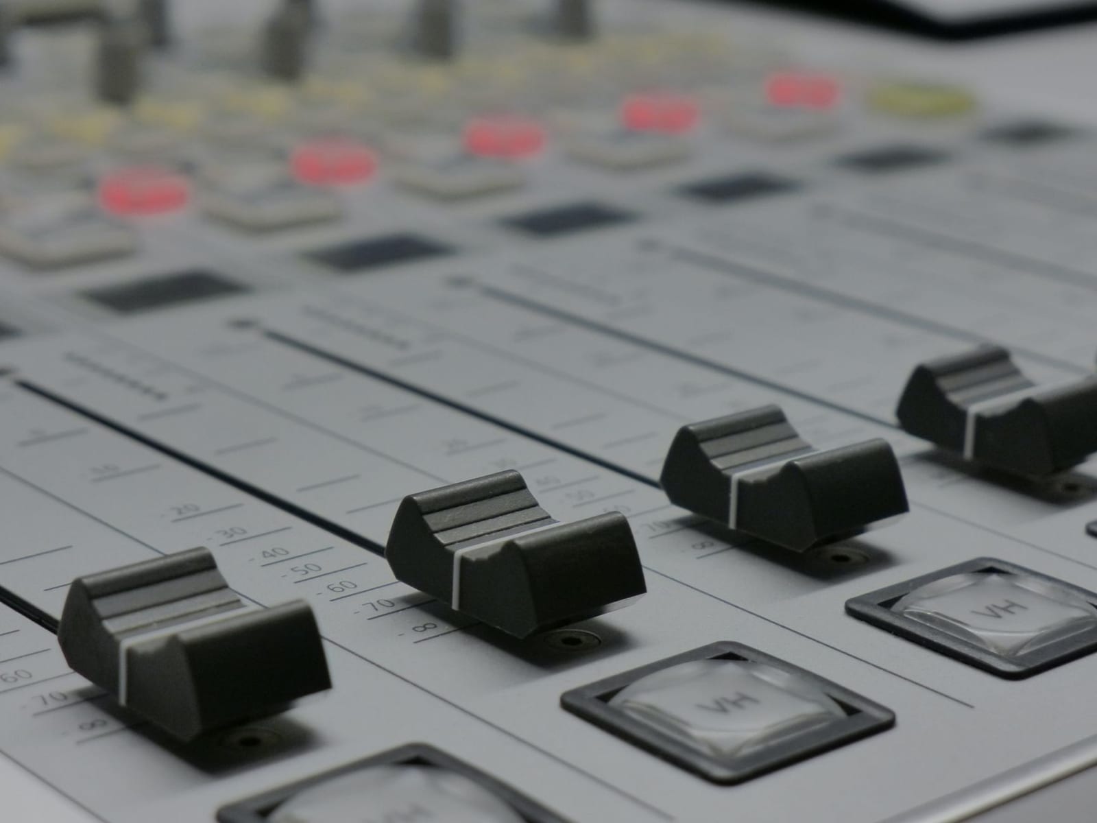 Close-up of the faders on an audio mixing console