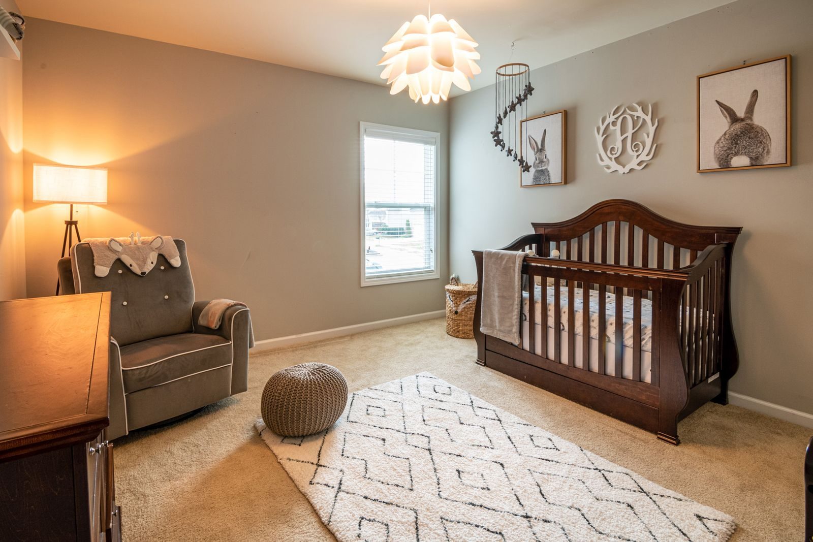 A warm nursery with a wooden crib, an armchair and soft decor