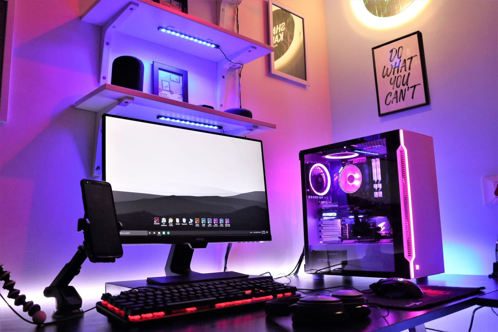 A desktop PC setup with RGB lighting, monitor and headphones