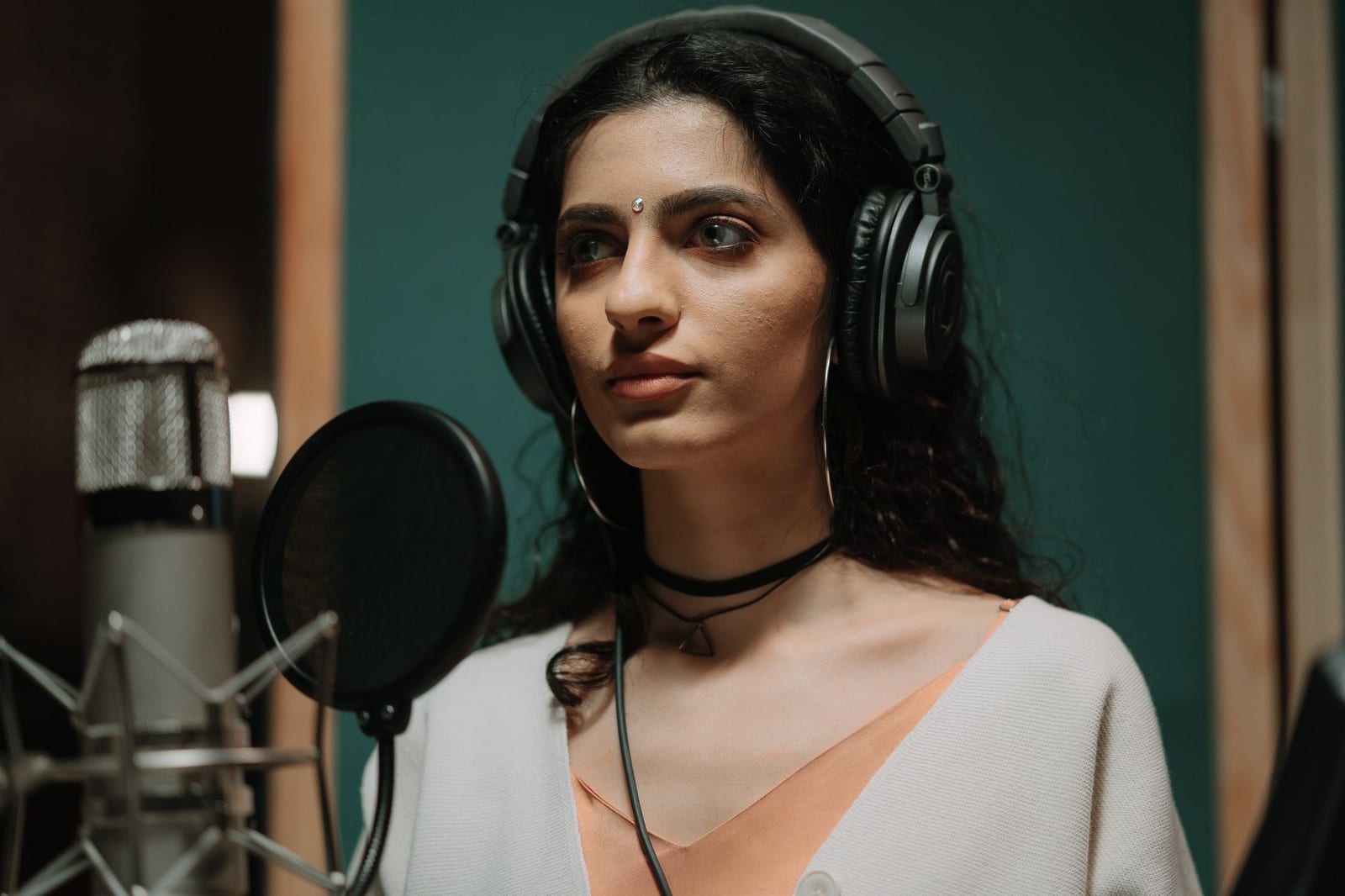 A singer recording vocals at a studio microphone