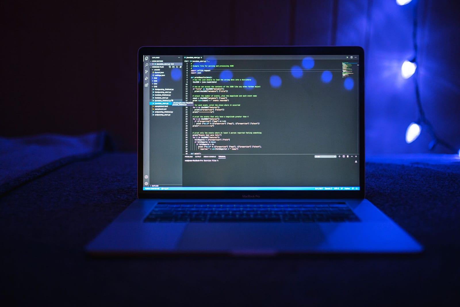A laptop showing code under blue light