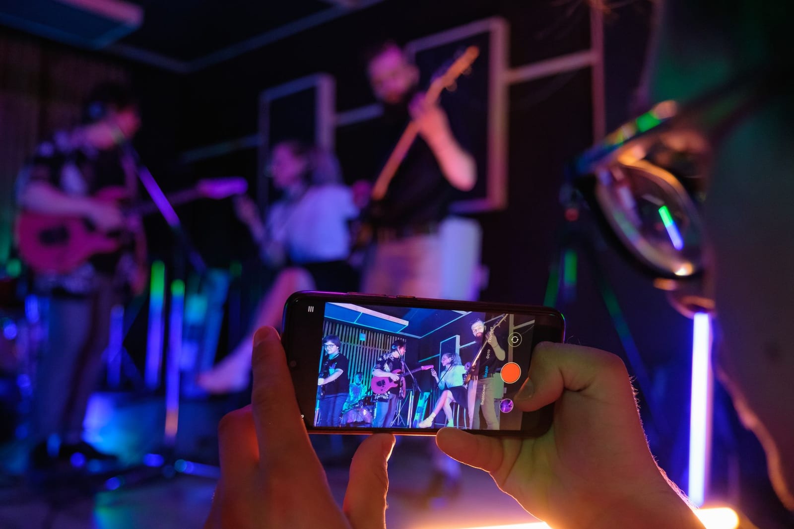 A smartphone filming a live band performance