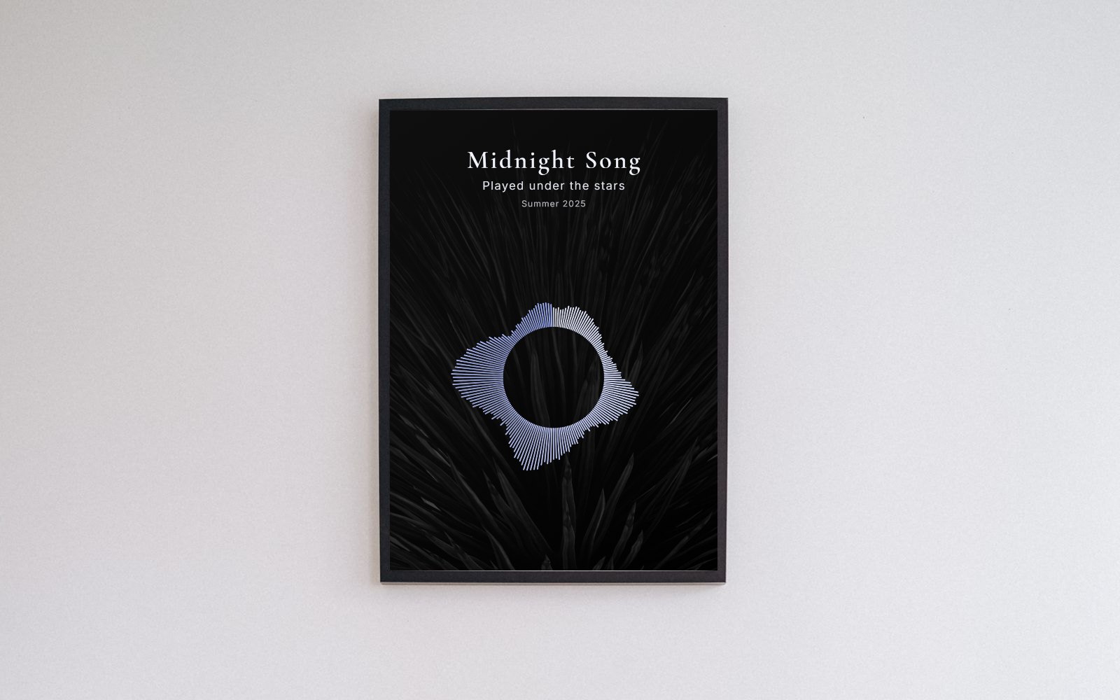 A framed sound wave print with a silver circular waveform on a dark background, hanging on a white wall