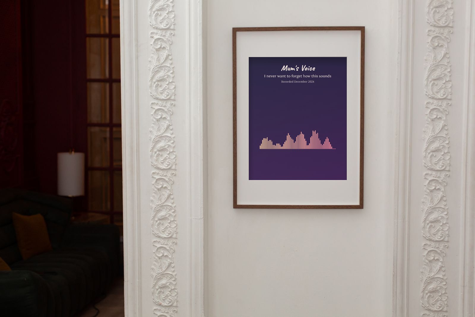 A wooden frame on a white panelled wall holding a purple poster titled Mum's Voice with a pink sound wave